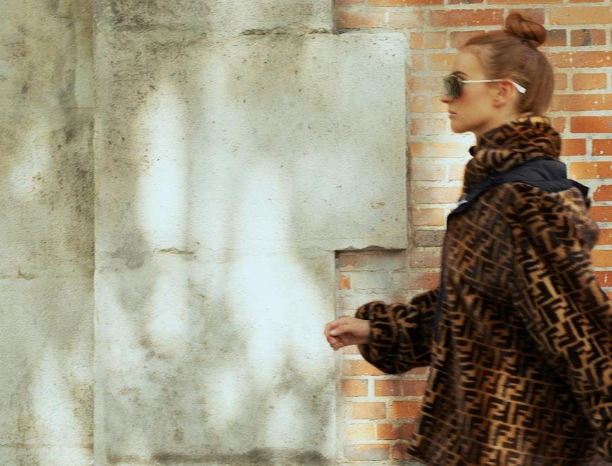 clothing apparel coat overcoat person human wall sleeve brick