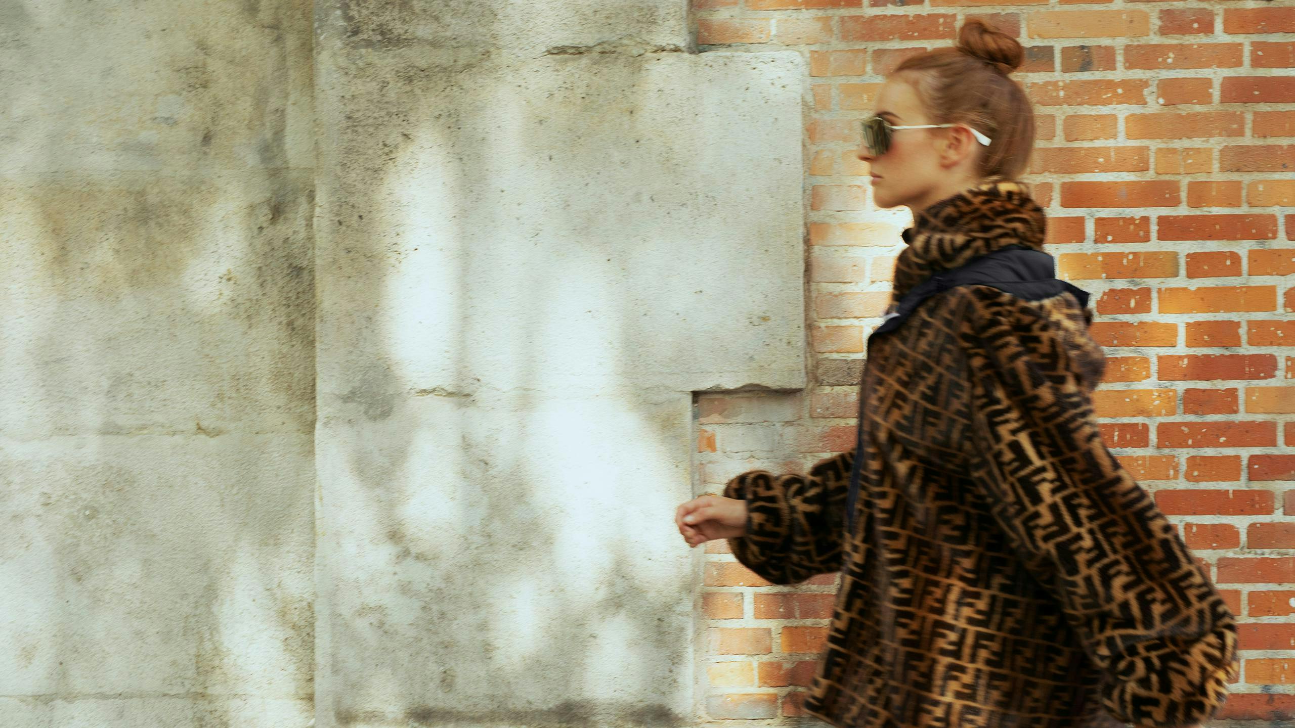 clothing apparel coat overcoat person human wall sleeve brick